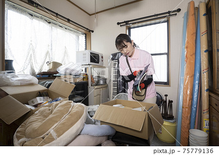 散らかった部屋を片付ける女性作業員 75779136
