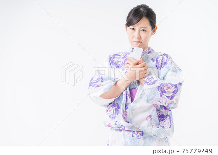 不機嫌そうにスマホを握りしめる浴衣姿の女性 不機嫌そうにスマホを握りしめる浴衣姿の女性 75779249