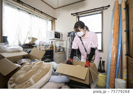 散らかった部屋を片付ける女性作業員 75779268