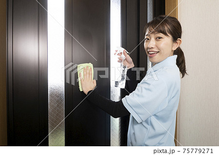 玄関の扉を拭くハウスクリーニング の女性 玄関の扉を拭くハウスクリーニング の女性 75779271