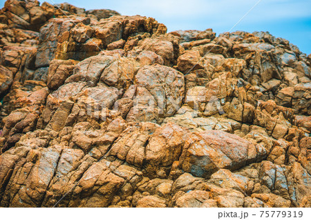 Close up view bright vivid orange brown yellow stone rock shabby cliff cracks texture mountains. Concept of geology, beauty power in nature. Natural summer composition landmark background design Close up view bright vivid orange brown yellow stone rock shabby cliff cracks texture mountains. Concept of geology, beauty power in nature. Natural summer composition landmark background design 75779319