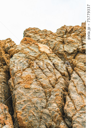 Close up view bright vivid orange brown yellow stone rock shabby cliff cracks texture mountains. Concept of geology, beauty power in nature. Natural summer composition landmark background design Close up view bright vivid orange brown yellow stone rock shabby cliff cracks texture mountains. Concept of geology, beauty power in nature. Natural summer composition landmark background design 75779337