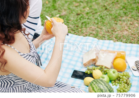 Young woman peeling orange Young woman peeling orange 75779906