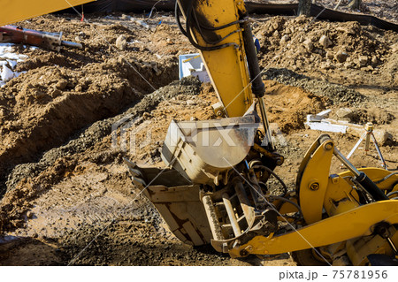 Excavator dig trench at construction site laying sewer wells and sewer pipes 75781956