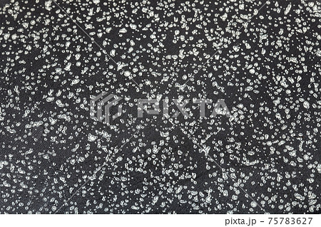 clean surface of a frying pan with a non-stick coating of dark color with a speck close-up, the texture of the coating of kitchen utensils. clean surface of a frying pan with a non-stick coating of dark color with a speck close-up, the texture of the coating of kitchen utensils. 75783627