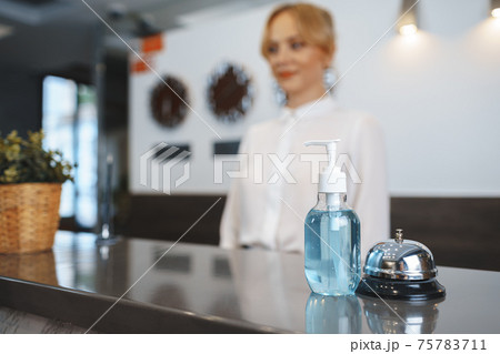 Hand sanitizer bottle on hotel reception desk Hand sanitizer bottle on hotel reception desk 75783711