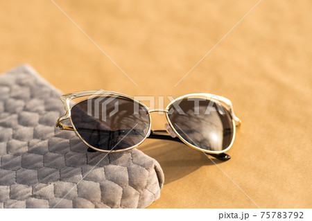 Fashion cat eye sunglasses model for ladies with black lenses shoot outside in a summer day closeup. Selective focus Fashion cat eye sunglasses model for ladies with black lenses shoot outside in a summer day closeup. Selective focus 75783792