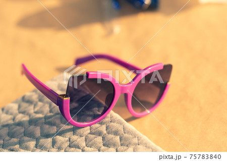 Cat eye sunglasses special model for women pink color shoot outside in a summer day closeup. Selective focus Cat eye sunglasses special model for women pink color shoot outside in a summer day closeup. Selective focus 75783840