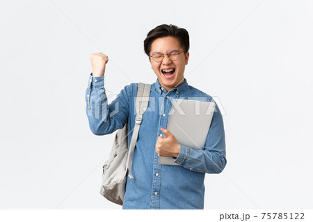 University, study abroad and lifestyle concept. Happy rejoicing asian male student with braces triumphing, pass exams, finish final semester, fist pump and shouting yes with satisfaction, hold laptop University, study abroad and lifestyle concept. Happy rejoicing asian male student with braces triumphing, pass exams, finish final semester, fist pump and shouting yes with satisfaction, hold laptop 75785122