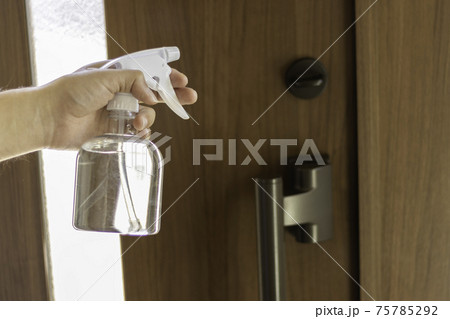 玄関ドアをアルコール消毒する男性 玄関ドアをアルコール消毒する男性 75785292