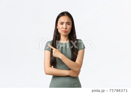 Small business owners, women entrepreneurs concept. Skeptical and unamused attractive businesswoman in dress smirk disappointed, pointing finger left at lame idea, white background Small business owners, women entrepreneurs concept. Skeptical and unamused attractive businesswoman in dress smirk disappointed, pointing finger left at lame idea, white background 75786371