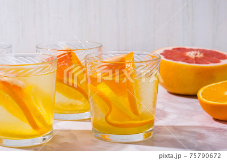 citrus lemonade and ingredients on white table. Fresh mixed fruits drink. Healthy eating, dieting citrus lemonade and ingredients on white table. Fresh mixed fruits drink. Healthy eating, dieting 75790672