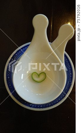 白い陶器の蓮華の上の葱のハート 75792016