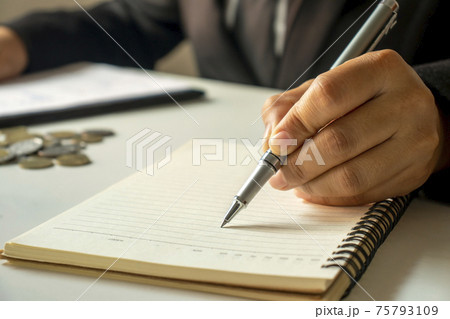 Business people take notes of income and expenses in notebook. Business people take notes of income and expenses in notebook. 75793109