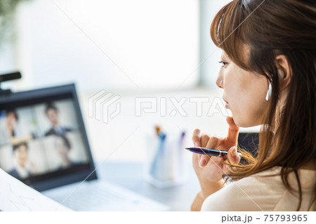 自宅のリビングでオンライン会議に参加する女性 75793965