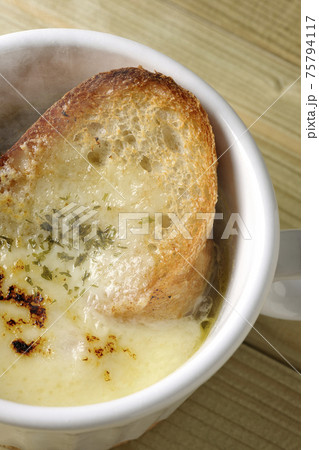 チーズに焦げ目のついてるフランスパンが入った熱々オニオンスープを俯瞰で撮影 チーズに焦げ目のついてるフランスパンが入った熱々オニオンスープを俯瞰で撮影 75794117