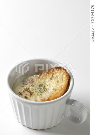カップで食べる熱々オニオングラタンスープを白背景で撮影 75794176
