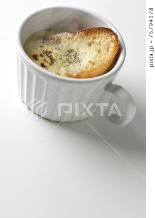カップで食べる熱々オニオングラタンスープを白背景で撮影 75794178