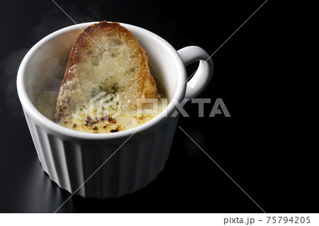 カップで食べる熱々オニオングラタンスープを黒背景で撮影 カップで食べる熱々オニオングラタンスープを黒背景で撮影 75794205