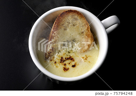 カップで食べる熱々オニオングラタンスープを黒背景で撮影(俯瞰) カップで食べる熱々オニオングラタンスープを黒背景で撮影(俯瞰) 75794248