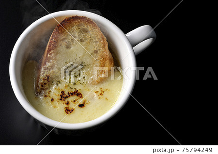 カップで食べる熱々オニオングラタンスープを黒背景で撮影（俯瞰） 75794249