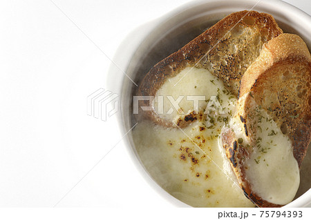 焦げ目のついたチーズ、フランスパンが入ってる熱々のオニオンスープを白背景で撮影（俯瞰） 75794393