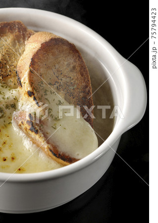 焦げ目のついたチーズ、フランスパンが入ってる熱々のオニオンスープを黒背景で撮影 焦げ目のついたチーズ、フランスパンが入ってる熱々のオニオンスープを黒背景で撮影 75794423