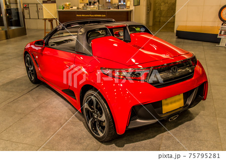 ショールームに展示された赤いスポーツカーを左後部から撮影の写真素材