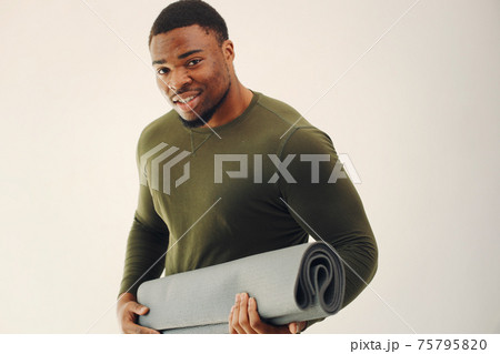 Handsome black man doing yoga on a white background Handsome black man doing yoga on a white background 75795820