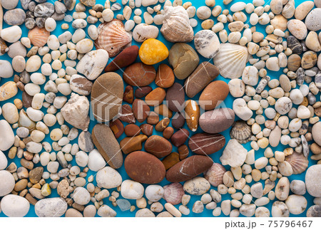 Sea pebbles and shells on a blue background Sea pebbles and shells on a blue background 75796467