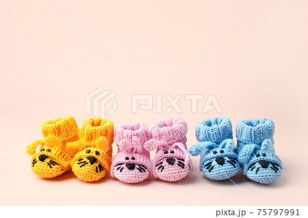 Pregnancy motherhood perenthood concept, Three pairs of baby booties on pastel background, baby shower, first birthday party banner, handmade socks, daycare, kindergarten, nursery, mother mom 75797991