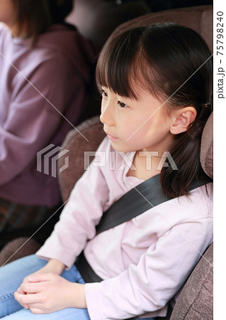 助手席に取り付けたジュニアシートに座る女の子 75798240
