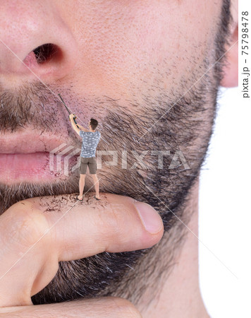 Man with miniature hedge trimmer shaving his own giant face Man with miniature hedge trimmer shaving his own giant face 75798478