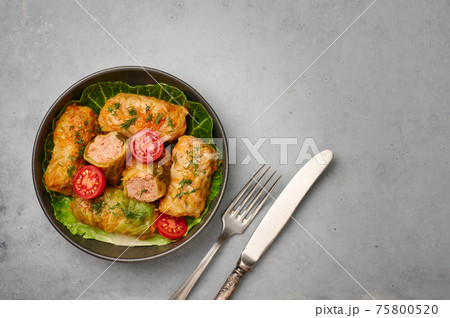 Golubtsi or golabki in bowl on concrete table top. Stuffed cabbage rolls of russian, polish cuisine Golubtsi or golabki in bowl on concrete table top. Stuffed cabbage rolls of russian, polish cuisine 75800520