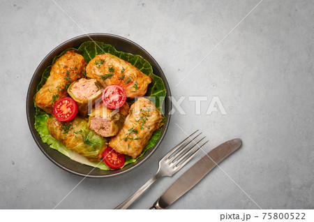 Golubtsi or golabki in bowl on concrete table top. Stuffed cabbage rolls of russian, polish cuisine Golubtsi or golabki in bowl on concrete table top. Stuffed cabbage rolls of russian, polish cuisine 75800522