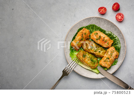 Golubtsi or golabki on plate on concrete table top. Stuffed cabbage rolls of russian, polish cuisine Golubtsi or golabki on plate on concrete table top. Stuffed cabbage rolls of russian, polish cuisine 75800523
