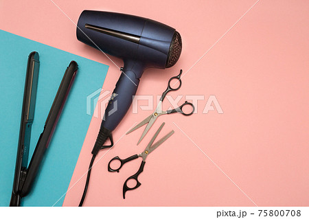 Professional hairdresser's equipment on color background. Hairdryer, scissors, and hair straightener. Professional hairdresser's equipment on color background. Hairdryer, scissors, and hair straightener. 75800708