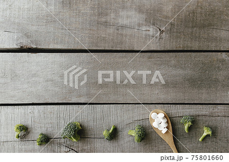 Vitamin or medicine pills, broccoli on wooden background. Health therapy concept Vitamin or medicine pills, broccoli on wooden background. Health therapy concept 75801660