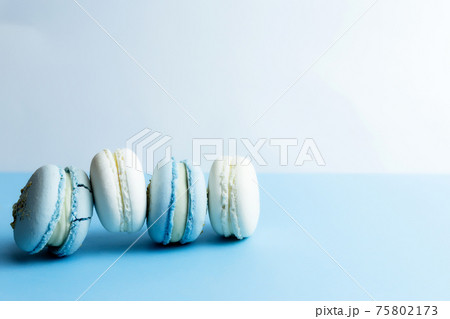 White and blue macaroons on the table, macaroons on white blue background 75802173