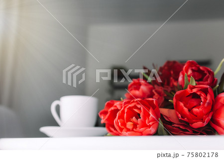 Bouquet of red tulips on table and white coffee cup. Concept for greeting card 75802178