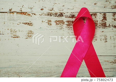 Pink ribbon breast cancer awareness on wooden background 75802473