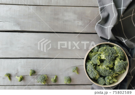 Green fresh broccoli in bowl on wooden background. Healthy eating concept Green fresh broccoli in bowl on wooden background. Healthy eating concept 75802589