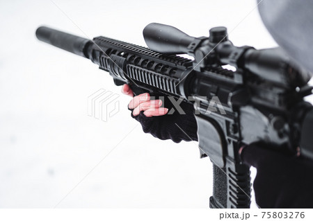 A military man in camouflage in winter with a rifle aims. 75803276