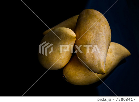 Ripe yellow barracuda mango fruit (Nam Dok Mai) on black table background. Ripe yellow barracuda mango fruit (Nam Dok Mai) on black table background. 75803417