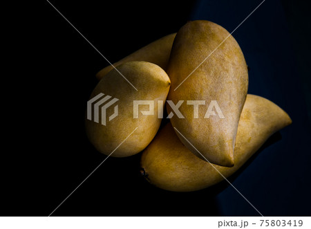Ripe yellow barracuda mango fruit (Nam Dok Mai) on black table background. 75803419
