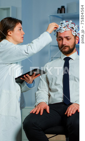 Man with brainwave scanning headset visiting professional doctor 75804564