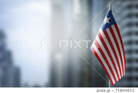 A small flag of Liberia on the background of a blurred background A small flag of Liberia on the background of a blurred background 75804652