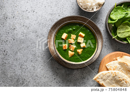 Palak Paneer served with basmati rice on grey. Indian vegetarian cuisine mades of spinach and paneer cheese. 75804848