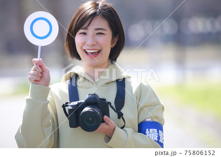 〇札を持つ女性カメラマン 75806152