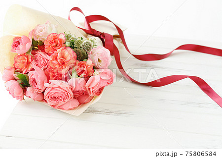 赤いリボンで結ばれたバラとカーネーションの花束の写真素材